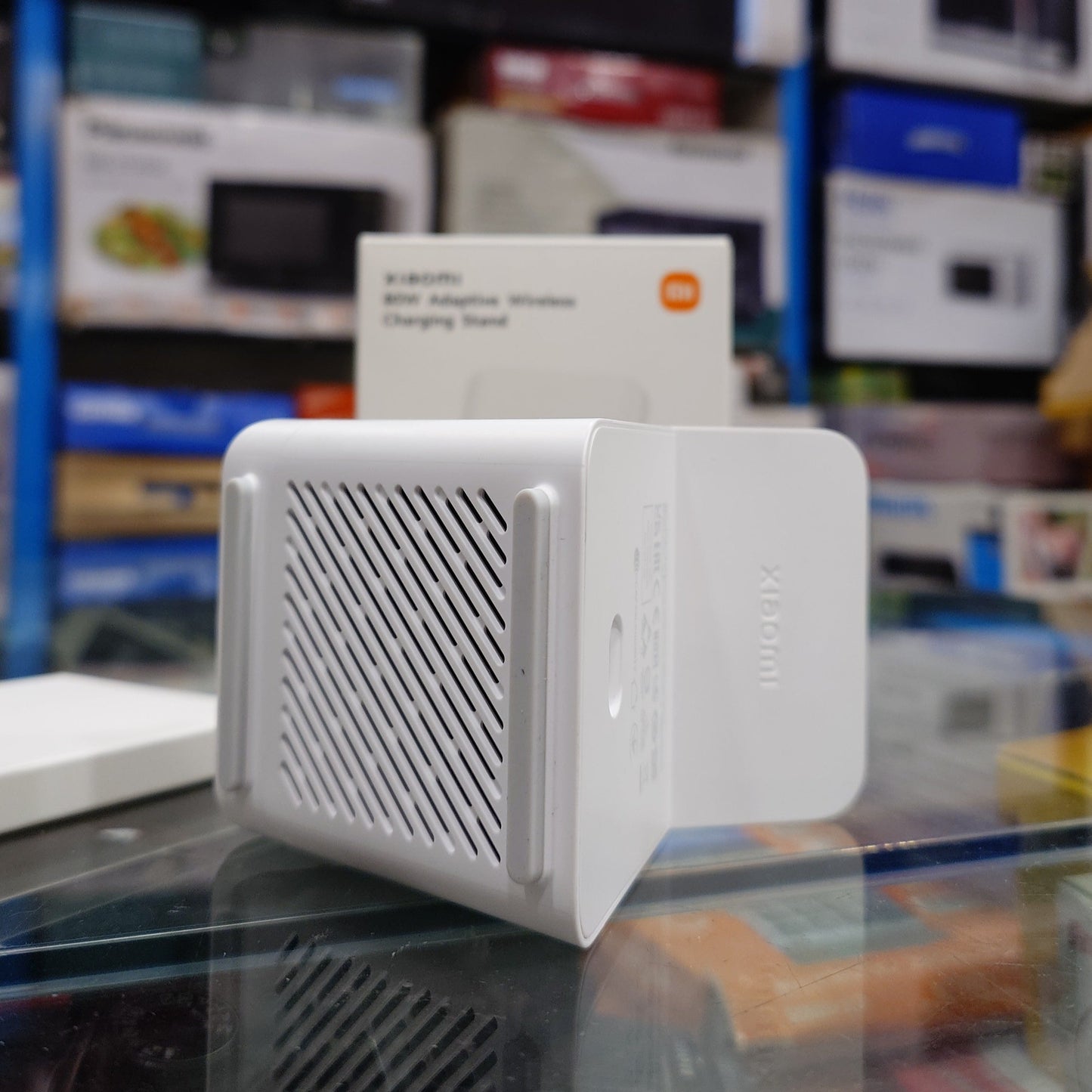 White electronic device with mesh design on top, displayed in a store setting.