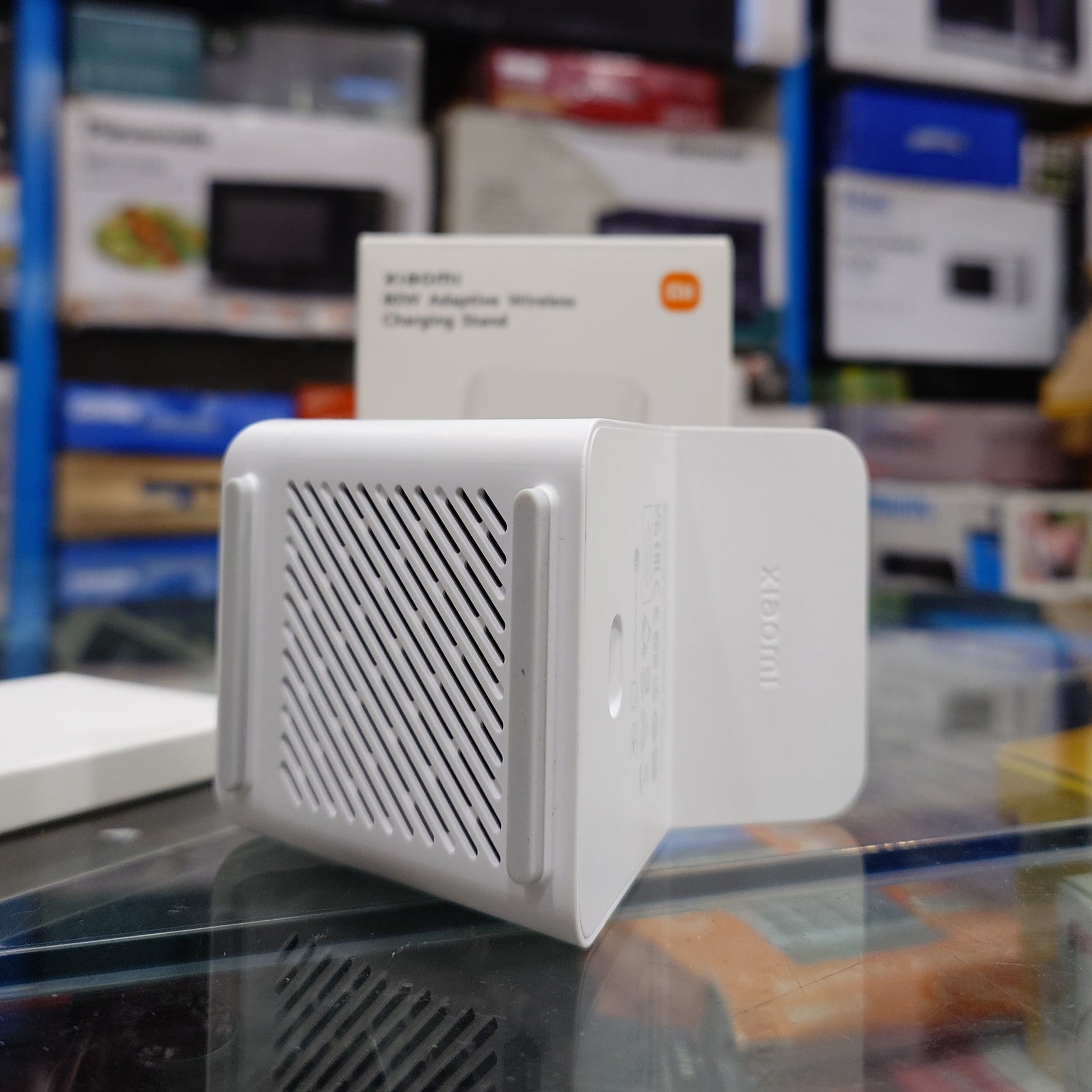 White electronic device with mesh design on top, displayed in a store setting.